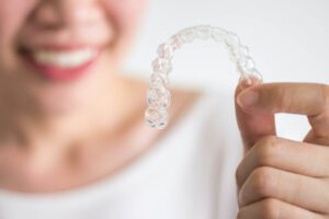 A woman looking at an invisible invisalign device.
