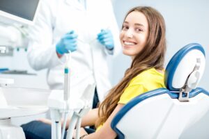 A woman sitting in the dentist chair smiling.